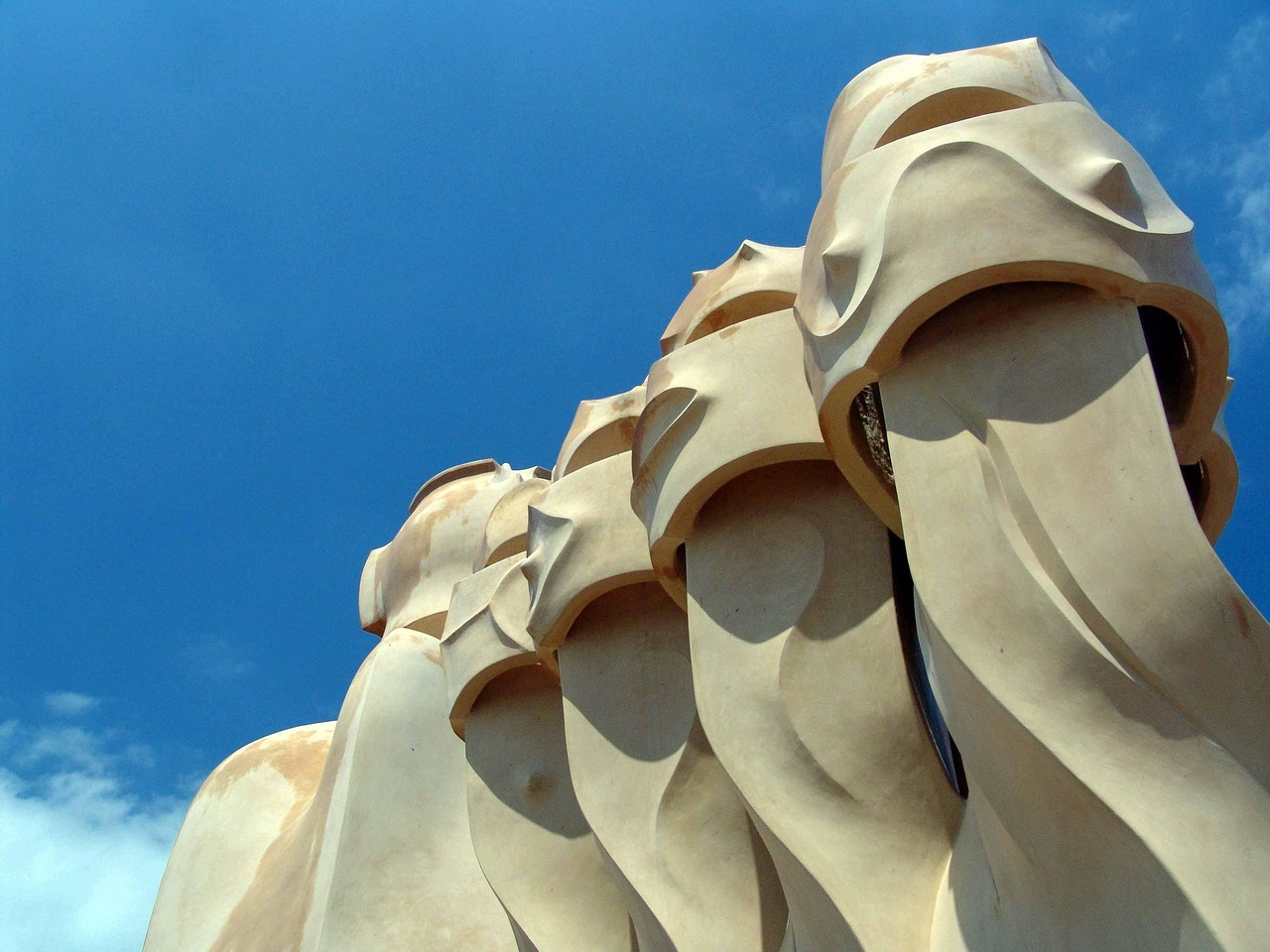 Unique, curved architectural structures against a blue sky.