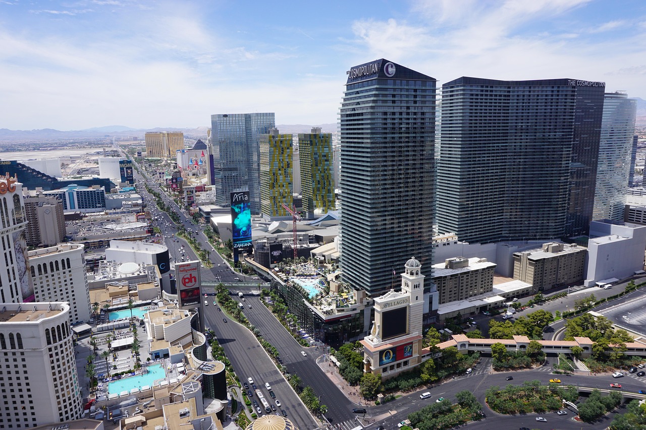 Aerial view of a bustling city with tall buildings, busy streets, and recognizable landmarks.
