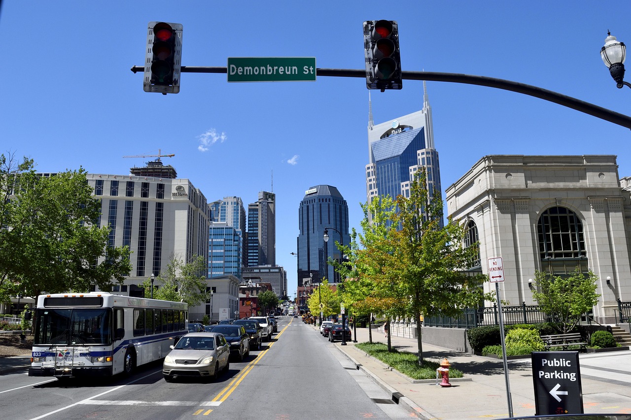 A busy city street with traffic, buildings, and a bus in Nashville, United States.