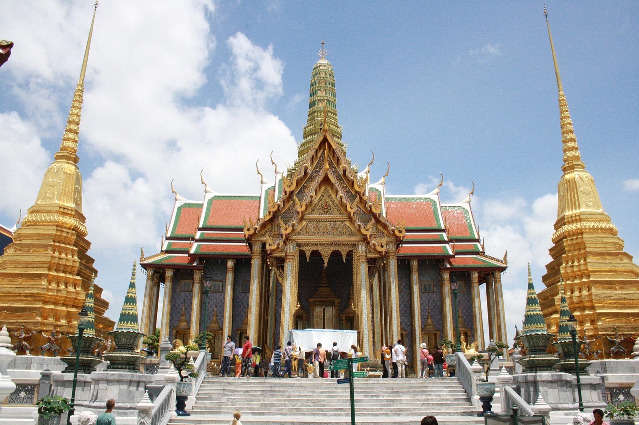 A grand temple with golden spires and intricate designs, surrounded by people visiting the site.