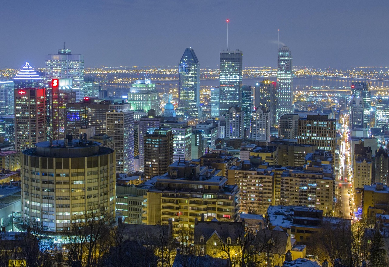 Nighttime cityscape of Montreal with illuminated buildings and skyline.