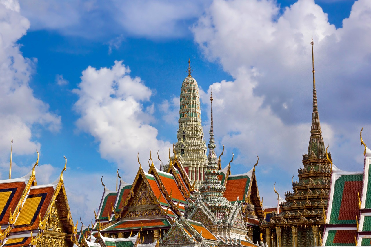 A view of ornate temples and spires under a blue sky with clouds.
