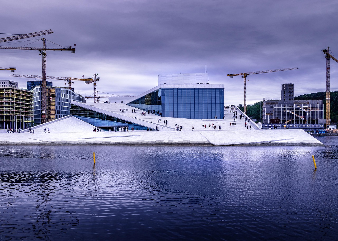 A modern urban waterfront scene with a distinctive white platform and surrounding buildings under construction.
