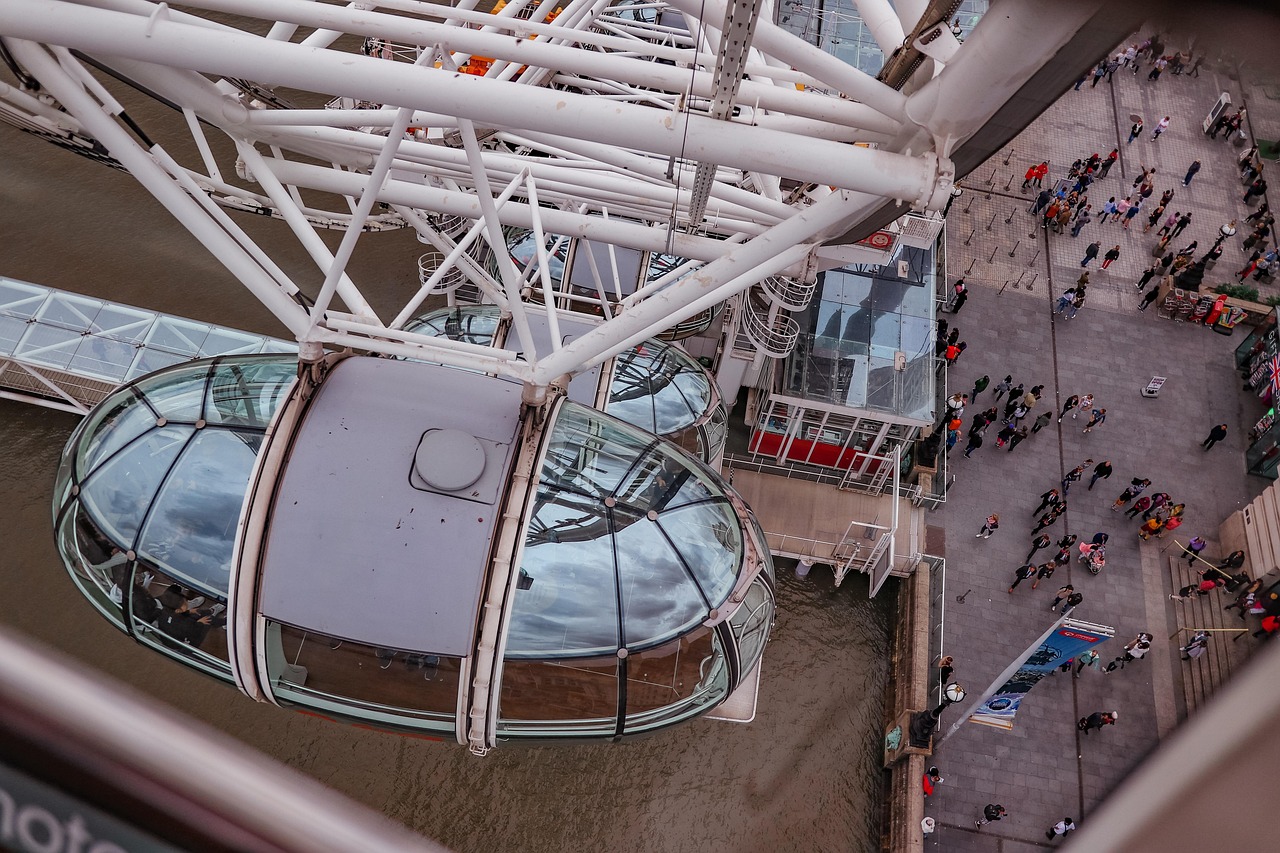 Aerial view of the London Eye with people queuing below and a capsule in the foreground.