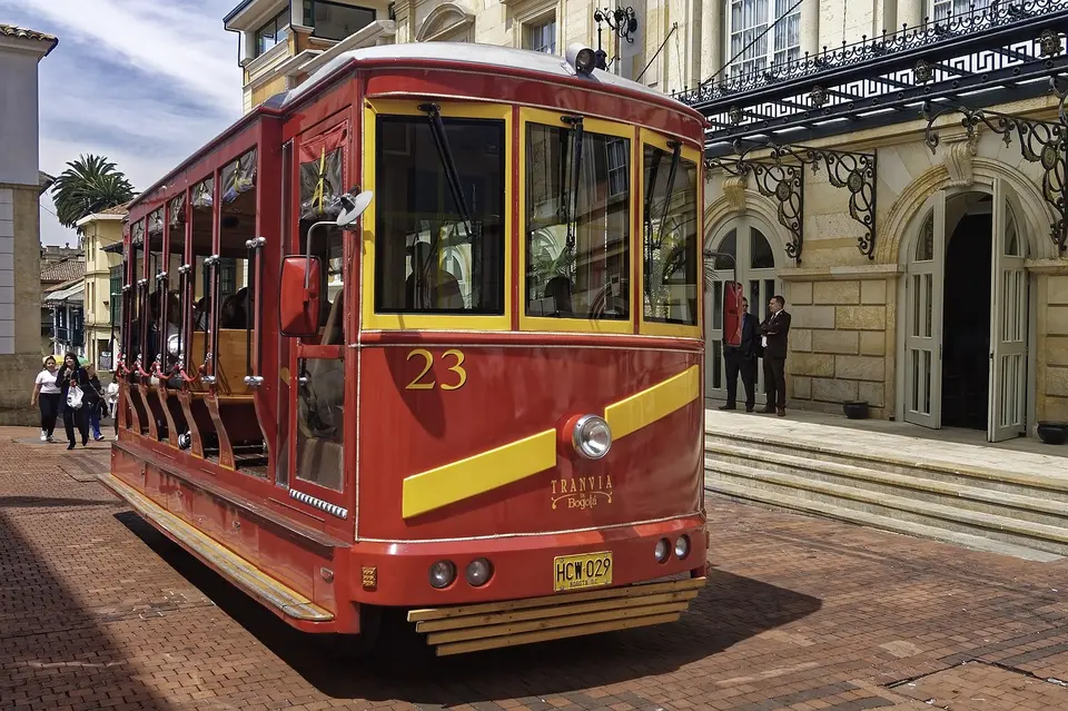 A red and yellow tram numbered 23 on tracks in front of a historic building with ornate architecture.