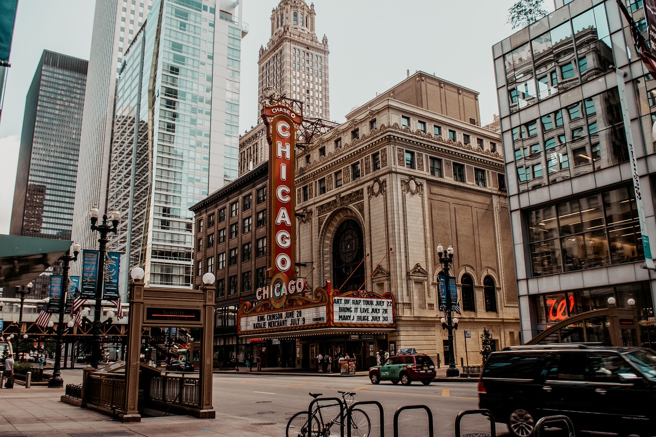 The Chicago Theatre with its marquee sign in a bustling city street surrounded by tall buildings.