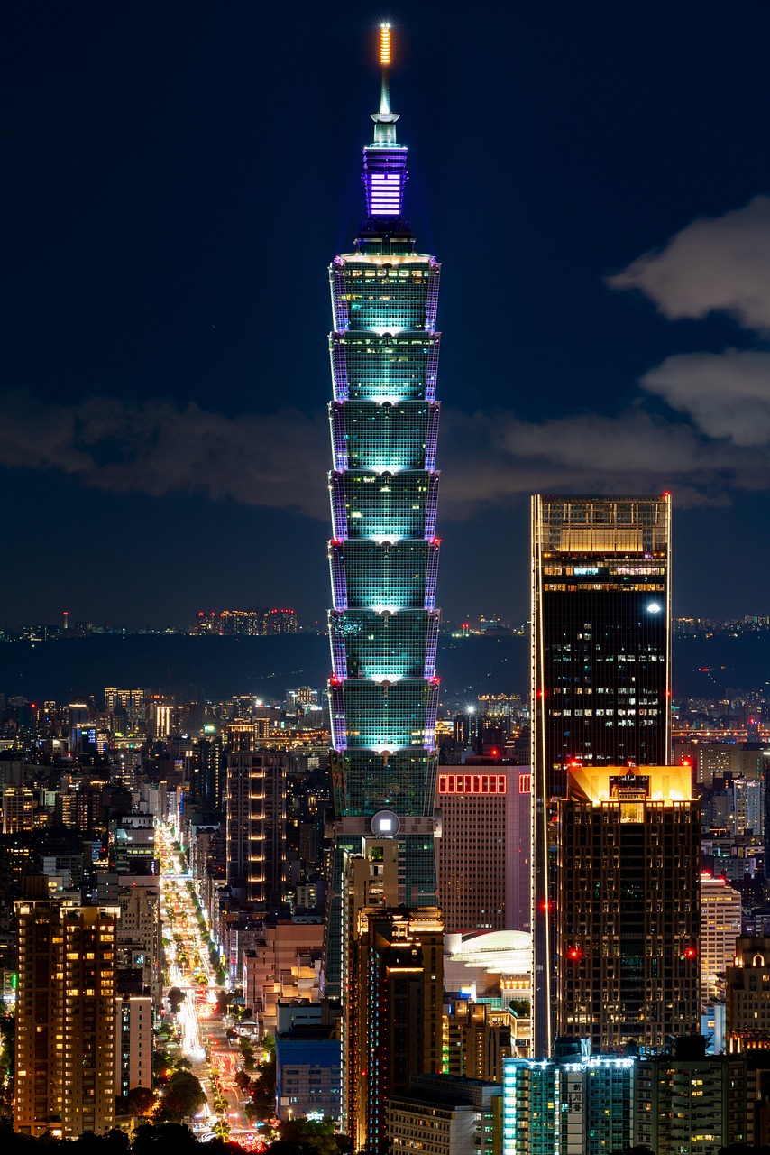 A nighttime cityscape featuring tall, illuminated skyscrapers.