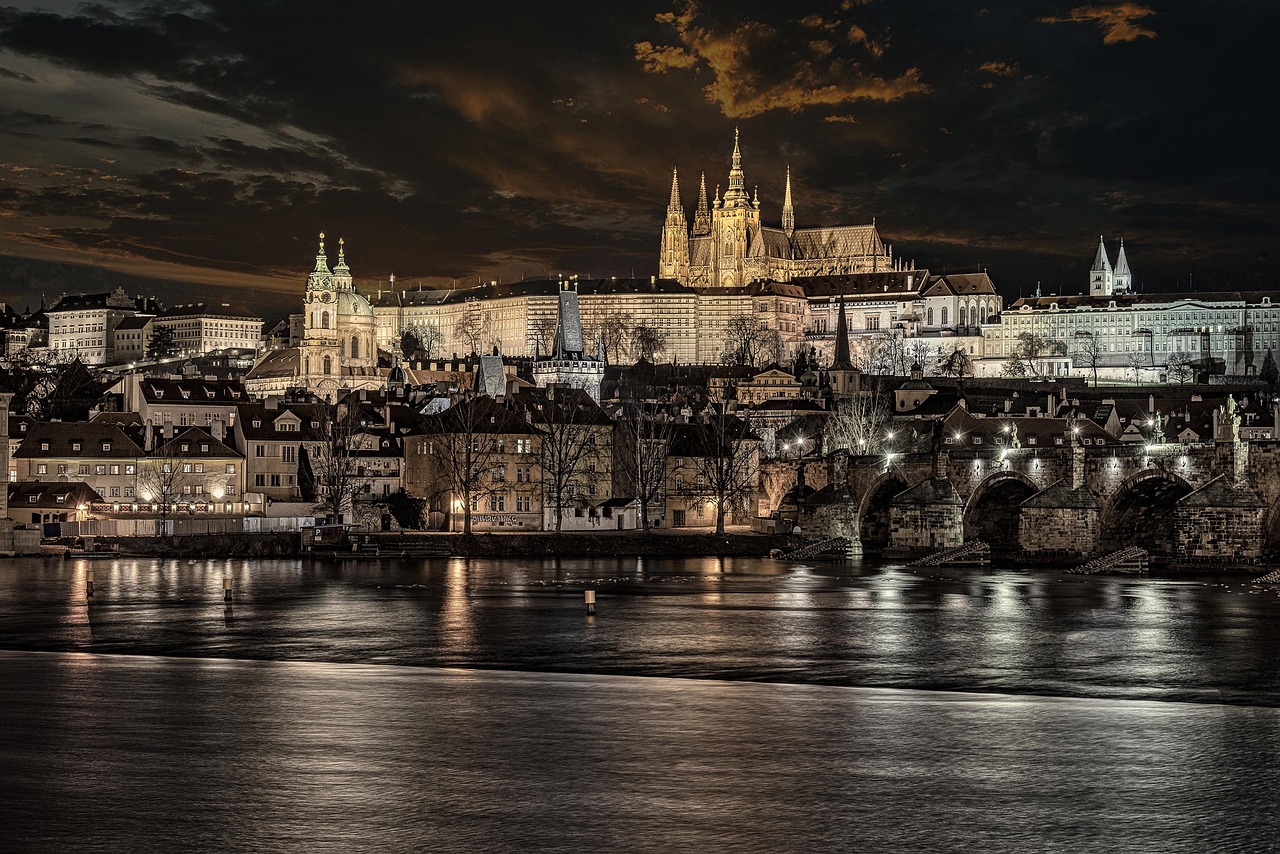 Night view of Prague with the Charles Bridge and Prague Castle illuminated.