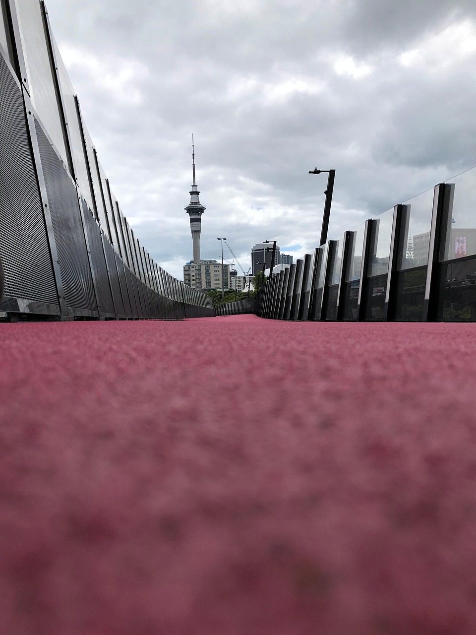 A view of a city skyline with a prominent tower in the background, seen through a series of vertical structures.