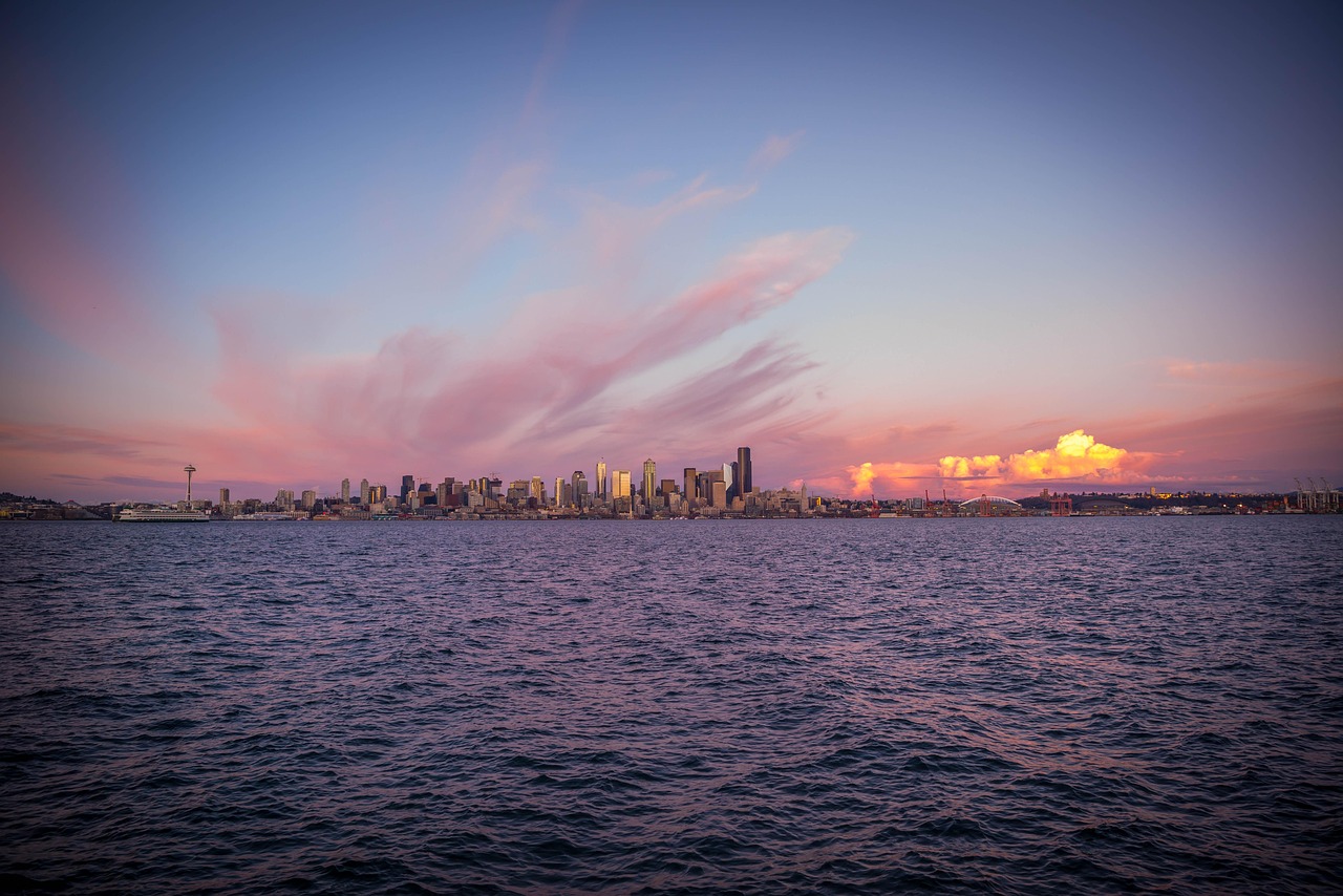 A city skyline at sunset over a body of water.