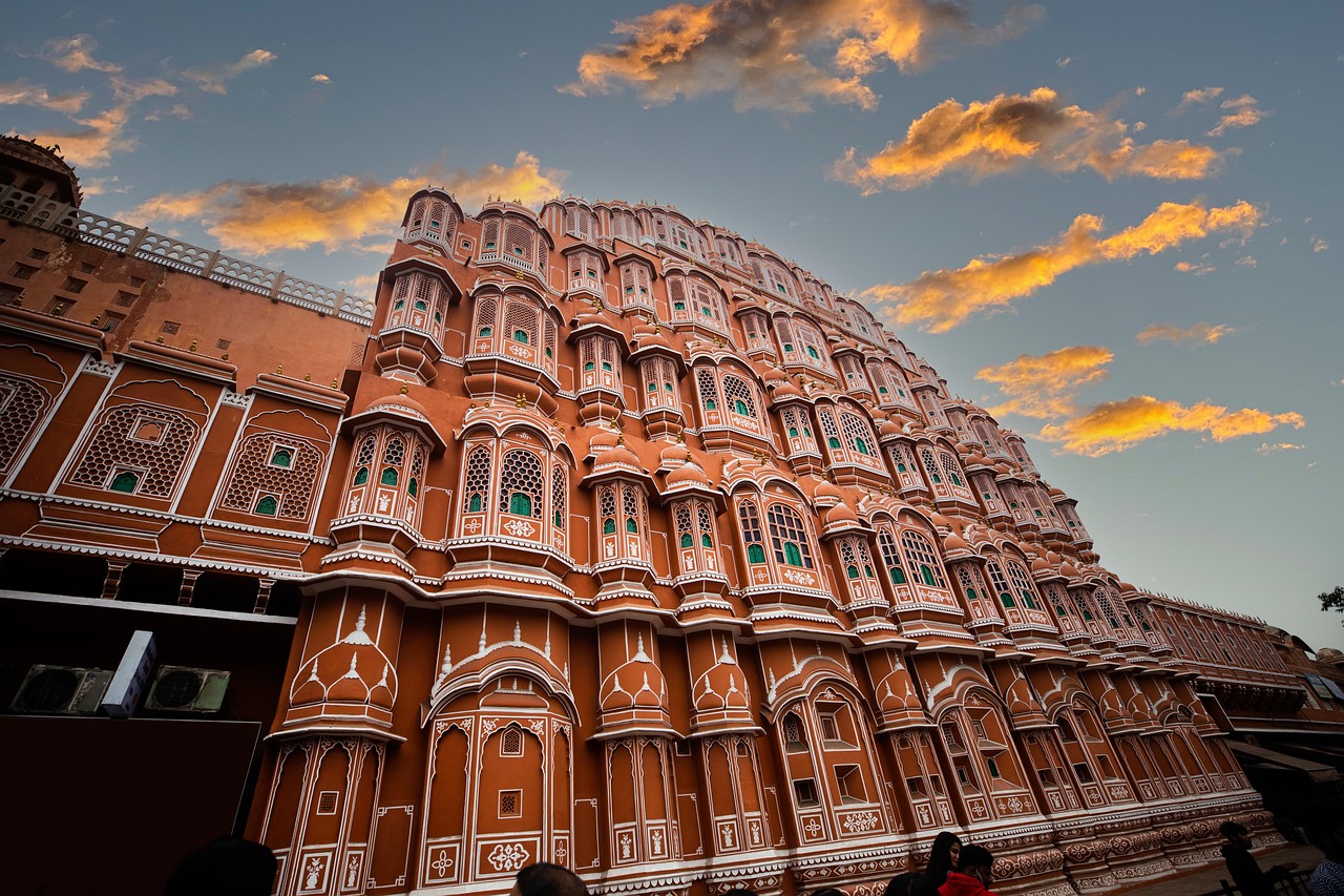 A grand pink and white building with intricate designs and balconies, captured during sunset.