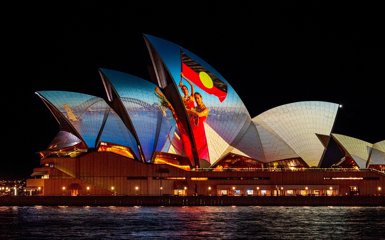 Sydney Opera House at night with a projection of indigenous art and people.