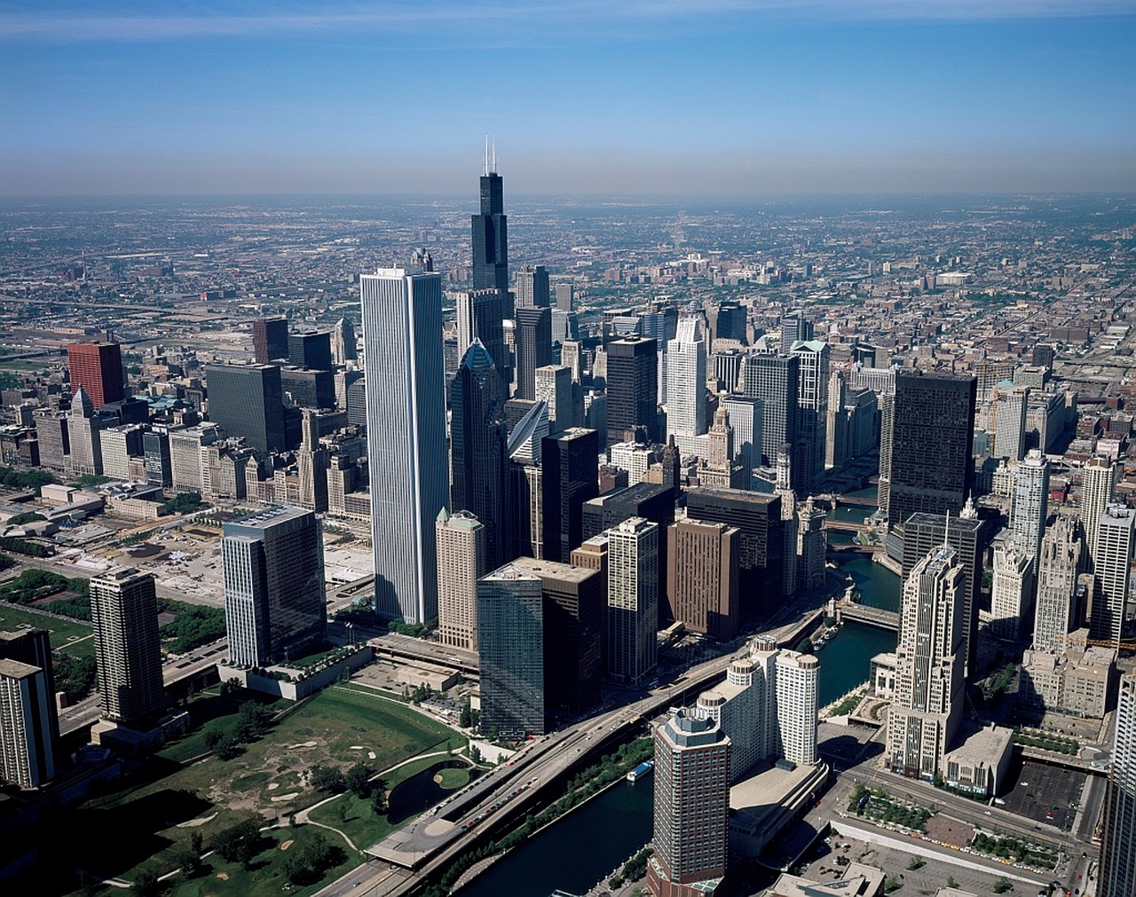 Aerial view of a city skyline with tall skyscrapers and a river running through it.